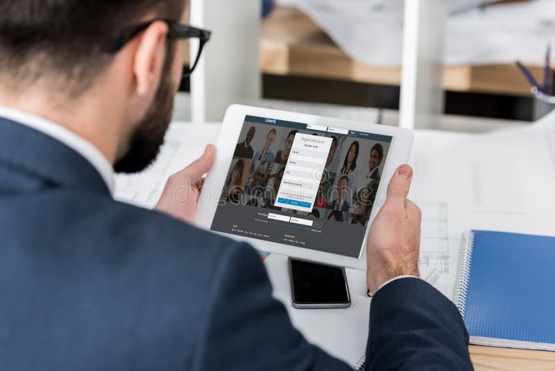 бизнесмен держа таблетку с нагруженной страницей linkedin стоковые фото