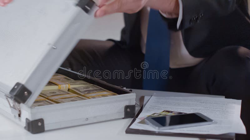 Бизнесмен проверяя деньги в портфеле, отскоке для политика, конце вверх стоковое фото rf Бизнесмен проверяя деньги в портфеле, отскоке для политика, конце вверх стоковое фото rf