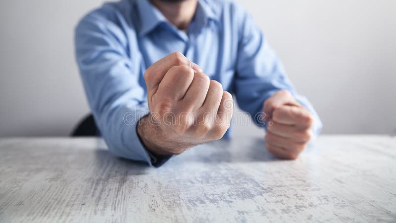 Businessman hits the table with his fists. Concept of anger. Businessman hits the table with his fists. Concept of anger