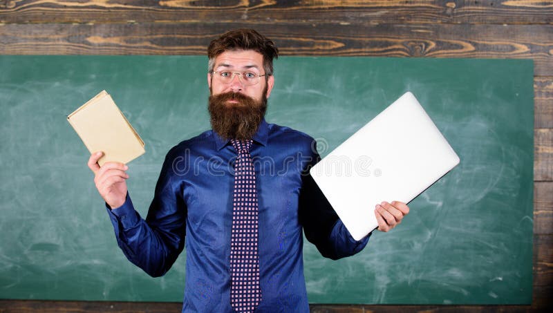 Teacher bearded hipster holds book and laptop. Choose right teaching method. Modern instead outdated. Teacher choosing modern teaching approach. Modern technologies benefit. Digital against paper. Teacher bearded hipster holds book and laptop. Choose right teaching method. Modern instead outdated. Teacher choosing modern teaching approach. Modern technologies benefit. Digital against paper.