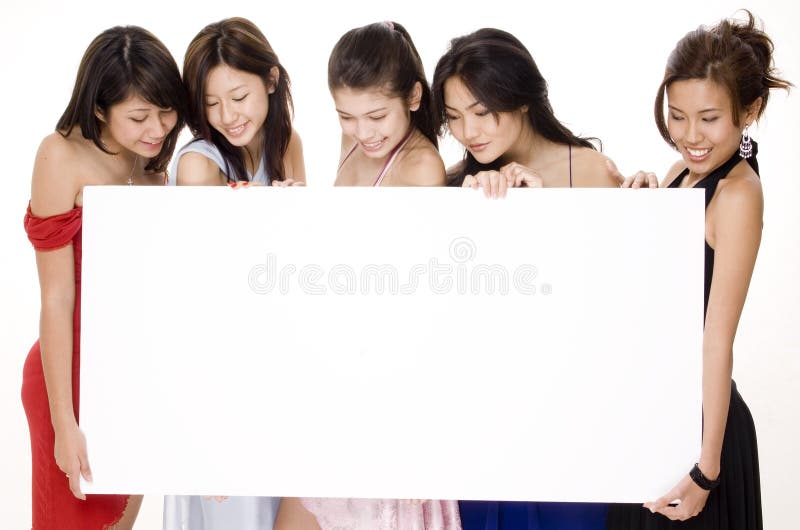 Five attractive asian women look at the blank sign they are holding. Five attractive asian women look at the blank sign they are holding