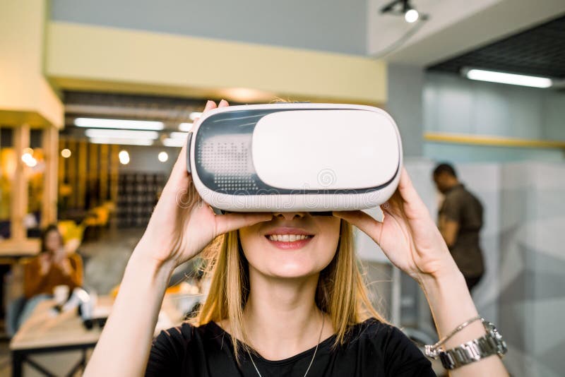Близкий портрет счастливо улыбающейся бизнес-женщины в очках vr, позирующих в современном офисе, в кибер-сетях, в будущем Молодые стоковая фотография rf Близкий портрет счастливо улыбающейся бизнес-женщины в очках vr, позирующих в современном офисе, в кибер-сетях, в будущем Молодые стоковая фотография rf