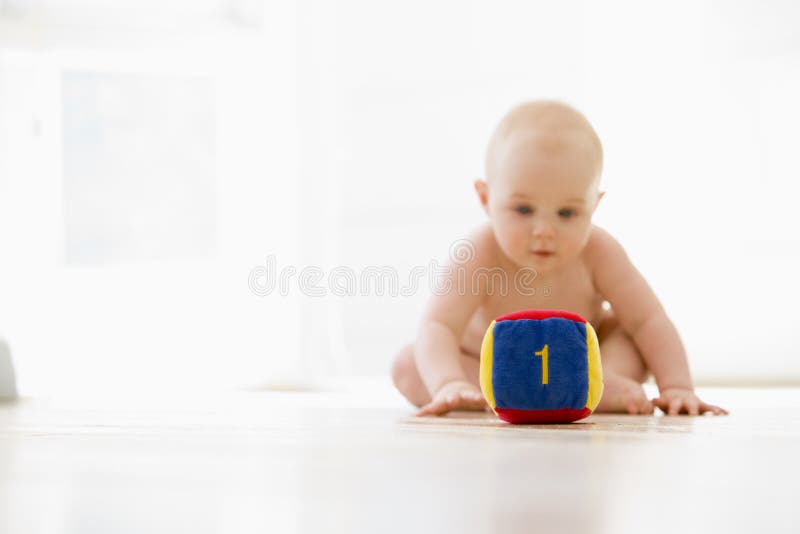Baby sitting indoors with block with white background. Baby sitting indoors with block with white background