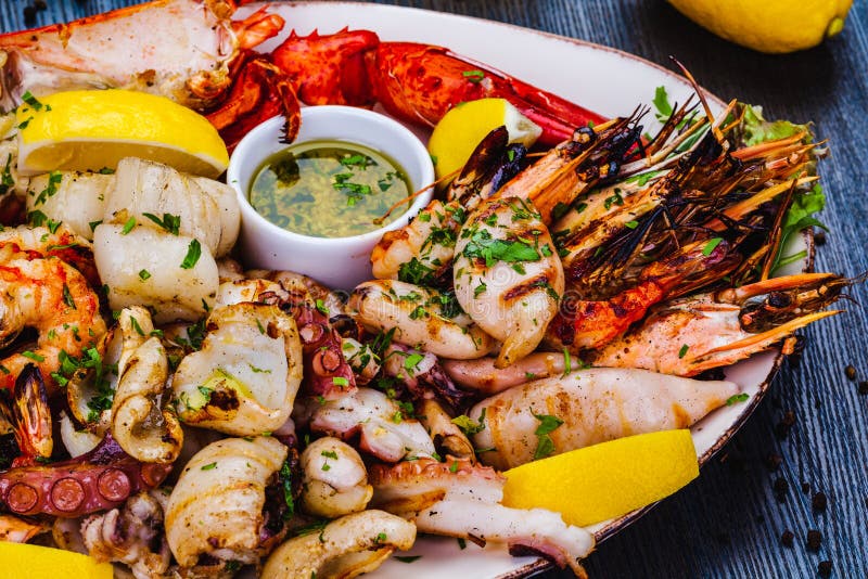 Блюда из морепродуктов. Жареные креветки, омар scallops кальмар осьминогов лангустов на белой тарелке стоковые изображения rf