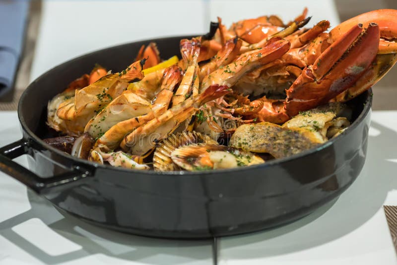 Блюда из морепродуктов. Жареные омар и морепродукты в кастрюле. стоковые фото