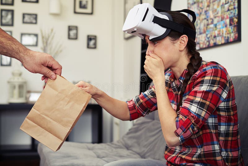 Woman sick after viewing virtual reality glasses, she takes a packet. Woman sick after viewing virtual reality glasses, she takes a packet