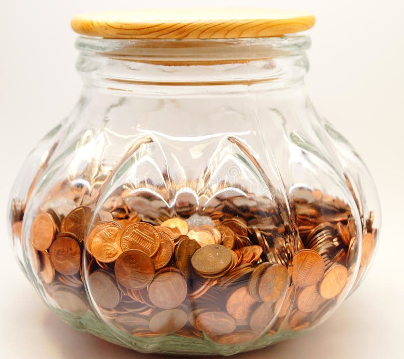 A large glass jar filled with pennies representing saving for college, retirement or something else in the future. A large glass jar filled with pennies representing saving for college, retirement or something else in the future.