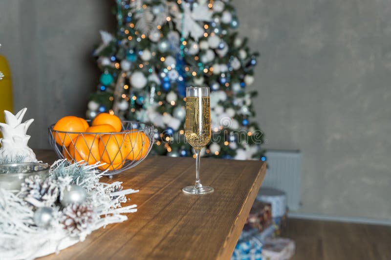 new year&#x27;s still life, 2 glasses of champagne tangerines on the table on the background of the Christmas tree. new year&#x27;s still life, 2 glasses of champagne tangerines on the table on the background of the Christmas tree