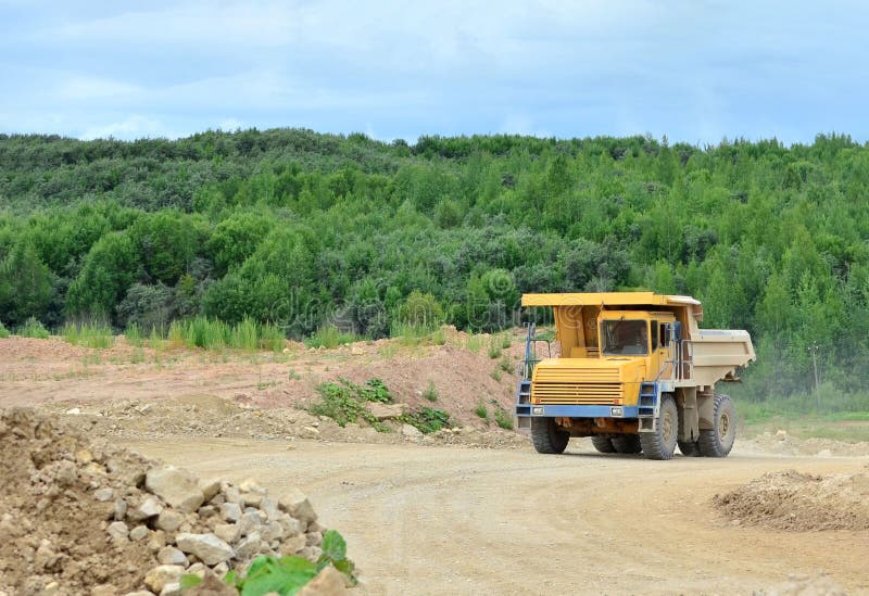 Большая желтая деятельность самосвала в открытом карьере известняка Загрузка и транспорт минералов в карьере минирования доломита стоковое изображение Большая желтая деятельность самосвала в открытом карьере известняка Загрузка и транспорт минералов в карьере минирования доломита стоковое изображение