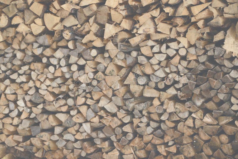 Large stack of logs chopped up for firewood, lightened & faded for background use in brochure. Large stack of logs chopped up for firewood, lightened & faded for background use in brochure