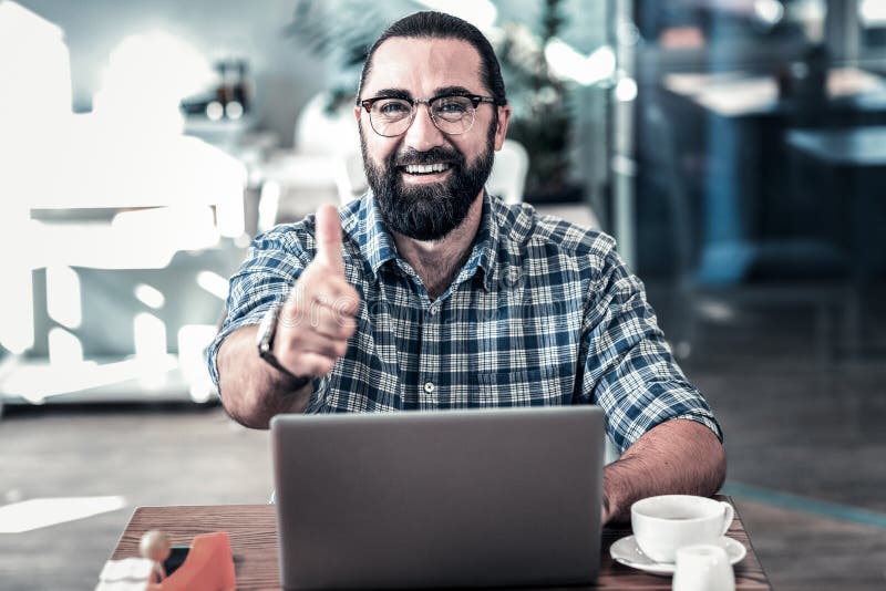 Бородатый темн-наблюданный бизнесмен одобряя работу его работников стоковое изображение