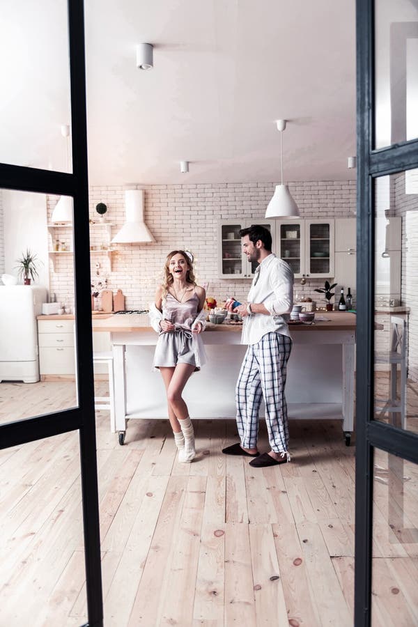 Бородатый темн-с волосами молодой человек имея потеху утра с его женой стоковые изображения