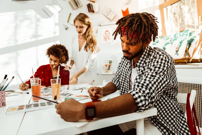 Бородатый темн-с волосами студент отделения гуманитарных наук с рисовать dreadlocks стоковая фотография