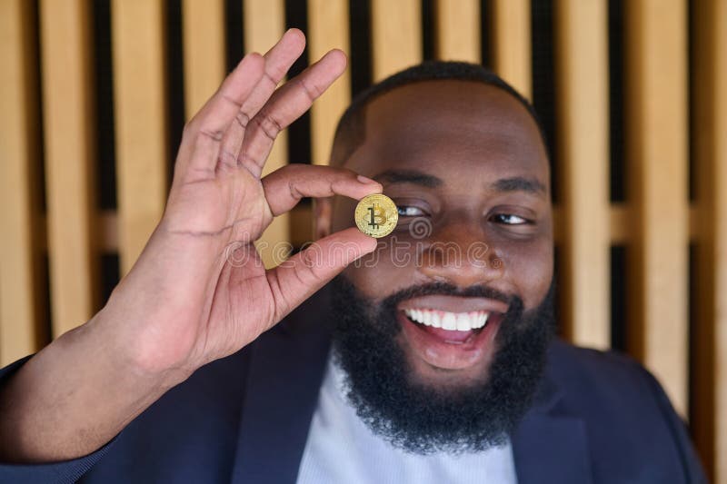 бородатый темнокожий мужчина, держащий биткоин стоковая фотография rf