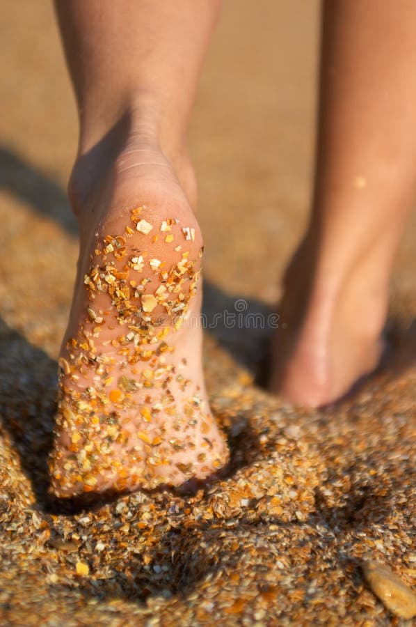 Women's barefoot legs on the sand beach. Women's barefoot legs on the sand beach