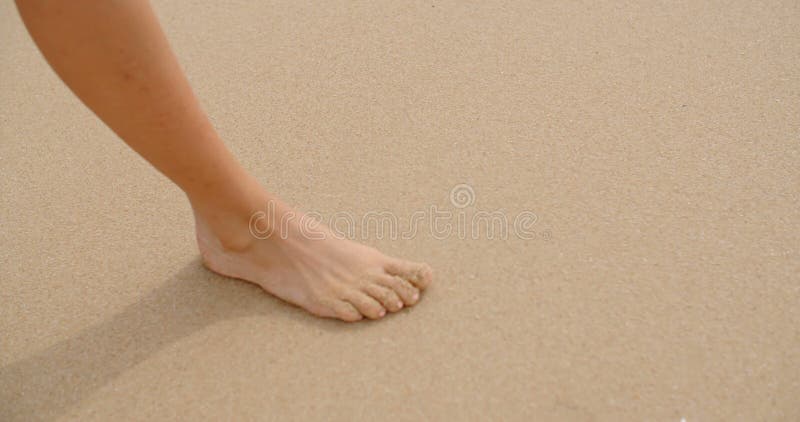 Босые ноги покрытые в песке идя на пляж
