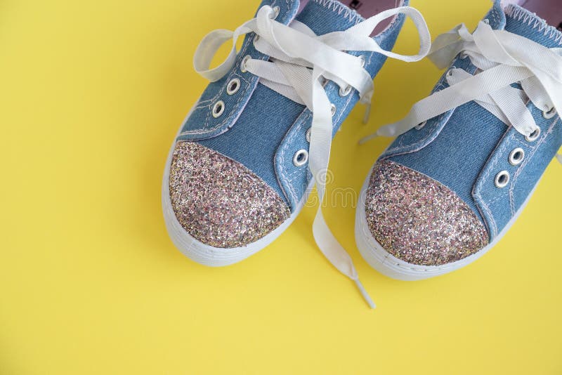 Ботинки детей джинсовой ткани со шнурками на желтом fashionpair backgroundkids модных кроссовок сияющий ребенка. Лето стоковое фото