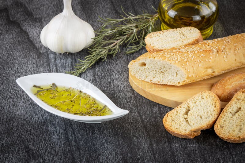 Боул с оливковым маслом, хлебом, чесноком, розмариновым и оливковым маслом в стеклянной бутылке Греческий хлеб стоковое изображение Боул с оливковым маслом, хлебом, чесноком, розмариновым и оливковым маслом в стеклянной бутылке Греческий хлеб стоковое изображение