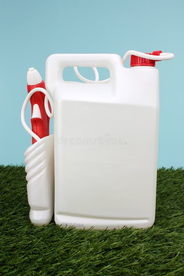 White And Red Spray Container In The Grass. White And Red Spray Container In The Grass