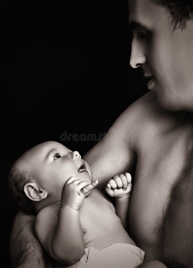 Будьте отцом держать его newborn младенца в его оружиях стоковые фото