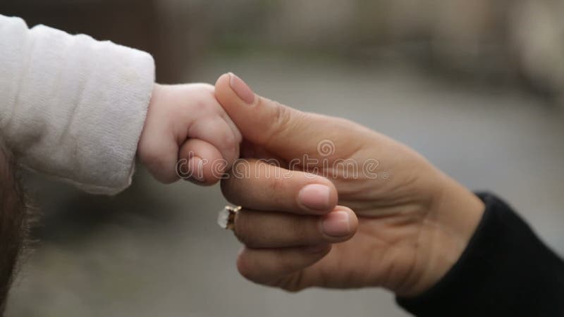 Будьте матерью держать меньшую руку младенца с нежностью и позаботьте, материнские чувства