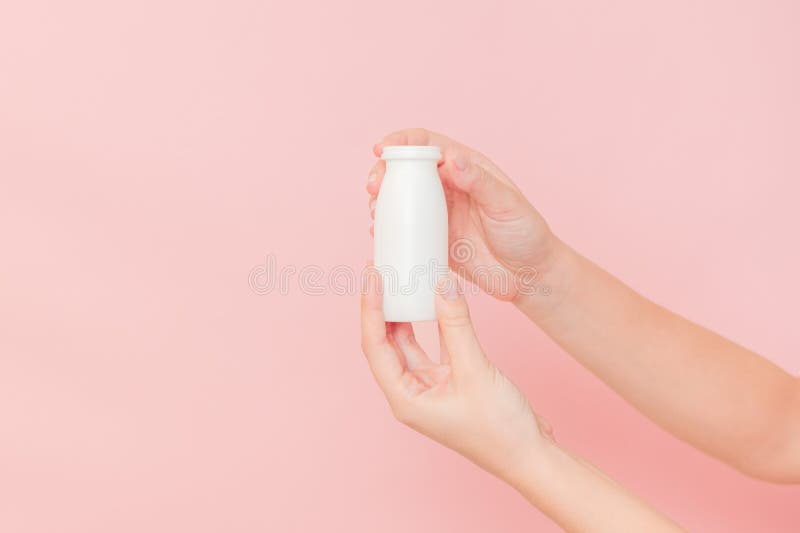 Hand holding a bottle of probiotic yogurt for digestive system. Dietary supplements for stomach. Hand holding a bottle of probiotic yogurt for digestive system. Dietary supplements for stomach