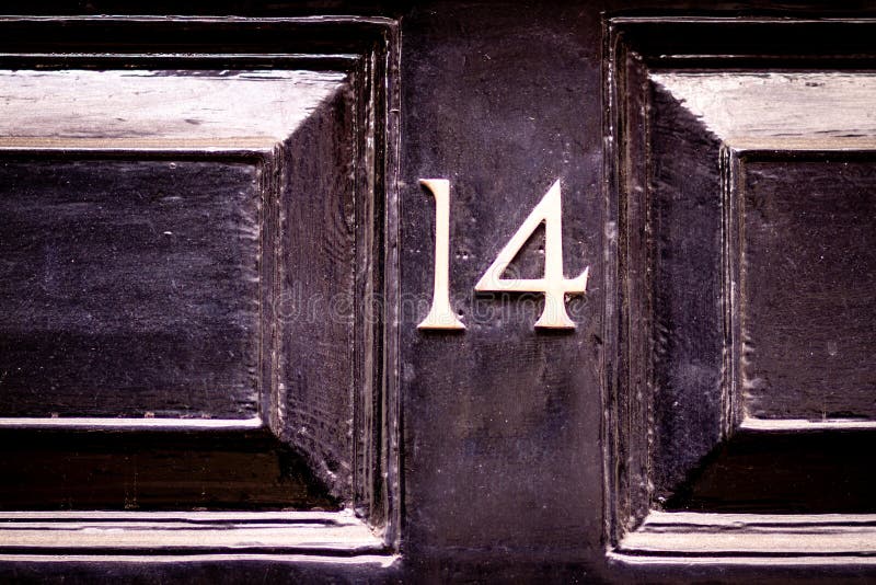 Black wooden front door with what looks like a circle around the fourteen. Black wooden front door with what looks like a circle around the fourteen