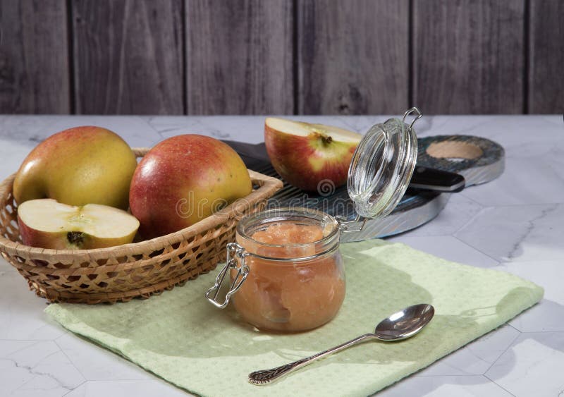 В отличии от яблони и applesauce плетеной тарелке на светлом фоне отрезанное apple на деревянной разделочной доске. стоковые фото