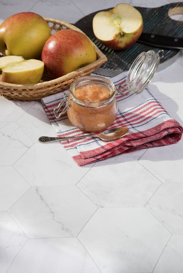 В отличии от яблони и applesauce плетеной тарелке на светлом фоне отрезанное apple на деревянной разделочной доске. стоковое изображение rf