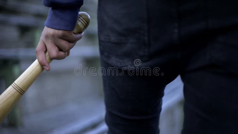 Вандализм, молодой человек идя на трибуну стадиона с бейсбольной битой, шатия молодости стоковые изображения rf Вандализм, молодой человек идя на трибуну стадиона с бейсбольной битой, шатия молодости стоковые изображения rf