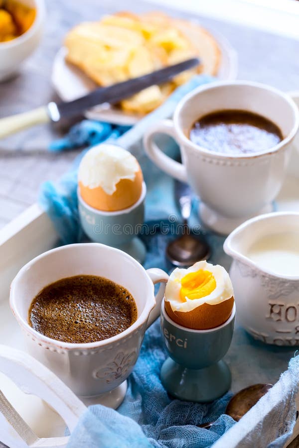 Breakfast for two. Strong coffee and 2 eggs hard boiled. Eggs and coffee are located on the white wooden tray. Breakfast for two. Strong coffee and 2 eggs hard boiled. Eggs and coffee are located on the white wooden tray.