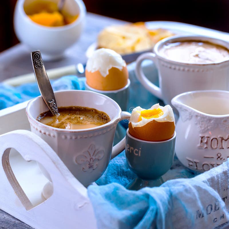 Breakfast for two. Strong coffee and 2 eggs hard boiled. Eggs and coffee are located on the white wooden tray. Breakfast for two. Strong coffee and 2 eggs hard boiled. Eggs and coffee are located on the white wooden tray.