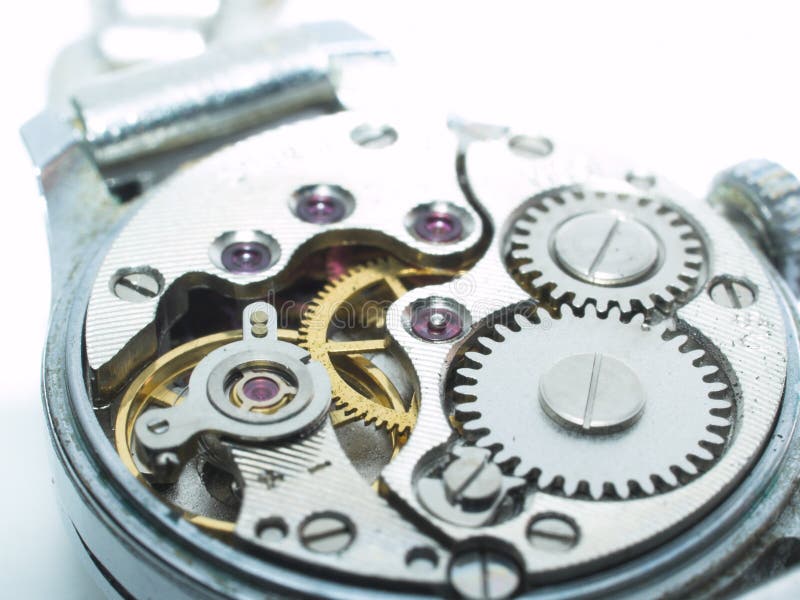 A closeup view of the internal gears and mechanism of a wristwatch. A closeup view of the internal gears and mechanism of a wristwatch.