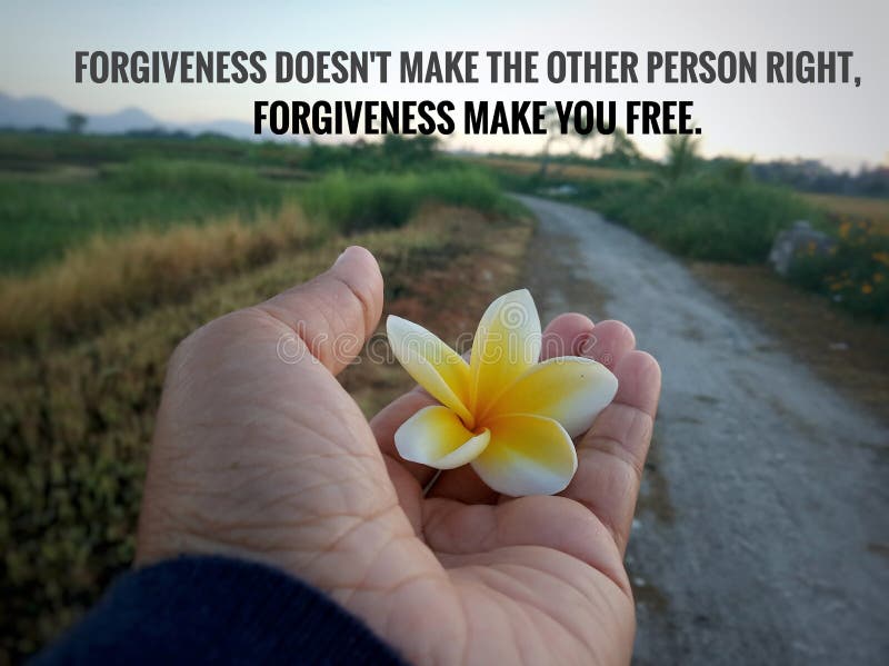 Inspirational quote - forgiveness does not make the other person right. Forgiveness make you free. With  flower in the hand on country road view. Forgiving and freedom concept. Inspirational quote - forgiveness does not make the other person right. Forgiveness make you free. With  flower in the hand on country road view. Forgiving and freedom concept