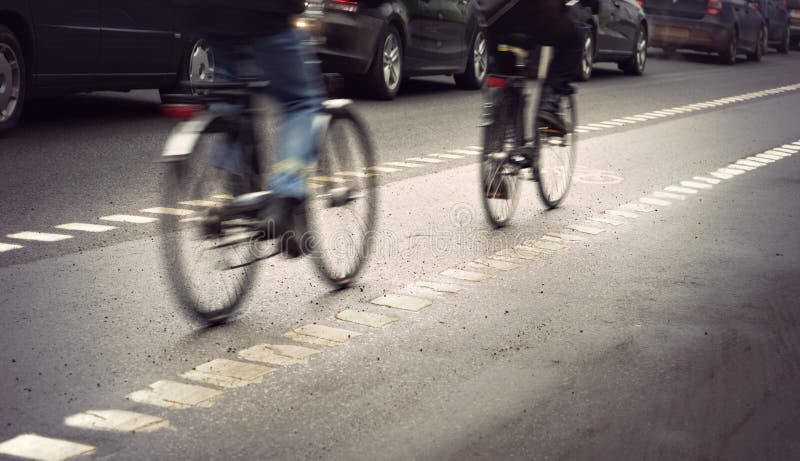 Cyclists in blurred motion in busy street on gloomy rainy day. Cyclists in blurred motion in busy street on gloomy rainy day