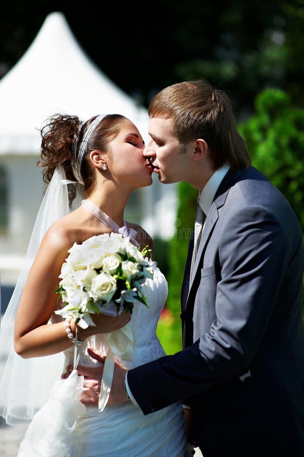 венчание прогулки парка поцелуя groom невесты счастливое стоковое изображение венчание прогулки парка поцелуя groom невесты счастливое стоковое изображение