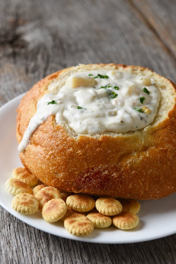 Вертикаль крупного плана густого супа Clam стиля Новой Англии в хлебе bo стоковая фотография rf Вертикаль крупного плана густого супа Clam стиля Новой Англии в хлебе bo стоковая фотография rf