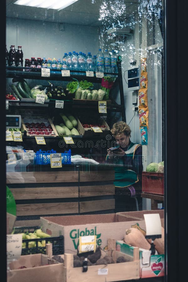 вертикальный выстрел пожилой женщины-продавца, сидящей в продуктовом магазине в Перм Руся стоковое изображение rf
