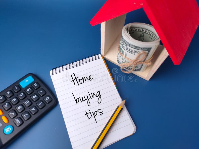 A top view of a toy house, calculator, notebook, and banknotes with the word Home buying tips. A top view of a toy house, calculator, notebook, and banknotes with the word Home buying tips