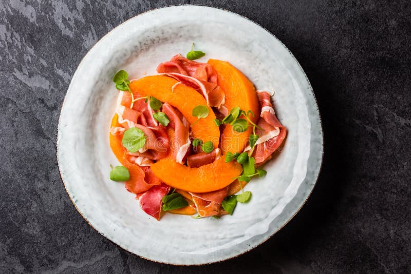 Download Ветчина Serrano Jamon, дыня и салат Arugula на серой плите Стоковое Изображение - изображение насчитывающей иберийско, closeup: 81802649
