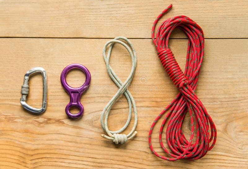 Взбираясь оборудование: rope, 8, штуцер на деревянной предпосылке, взгляд сверху стоковые фотографии rf Взбираясь оборудование: rope, 8, штуцер на деревянной предпосылке, взгляд сверху стоковые фотографии rf