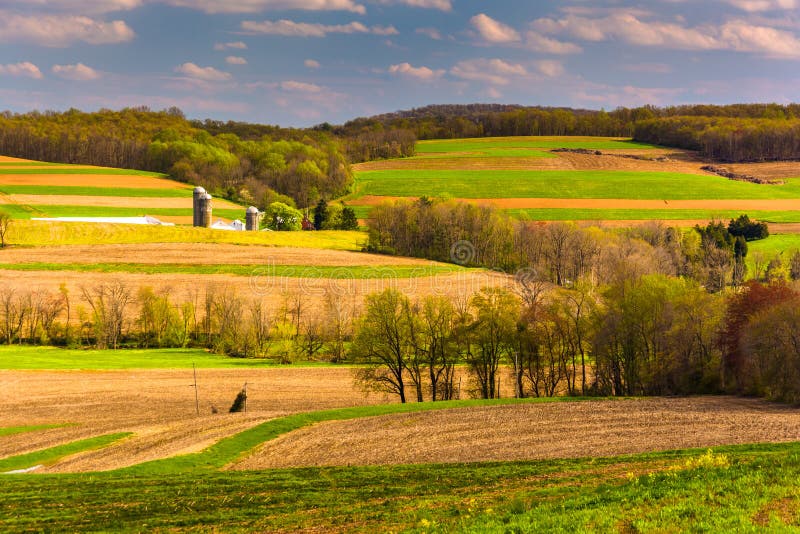 Взгляд весны полей Rolling Hills и фермы в сельском Йорке подсчитывает стоковое изображение