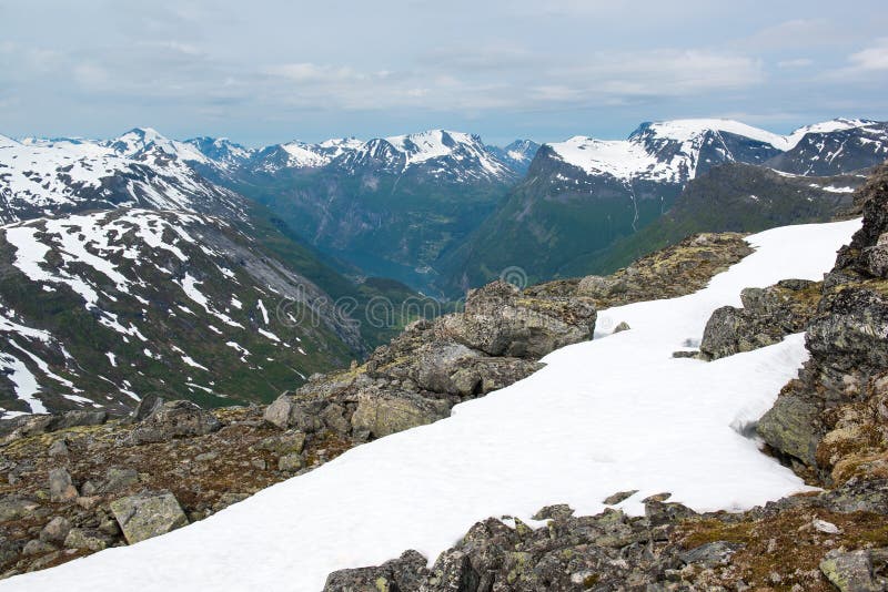 Взгляд от горы Dalsnibba к фьорду Geiranger и горным пикам, Норвегии стоковая фотография Взгляд от горы Dalsnibba к фьорду Geiranger и горным пикам, Норвегии стоковая фотография