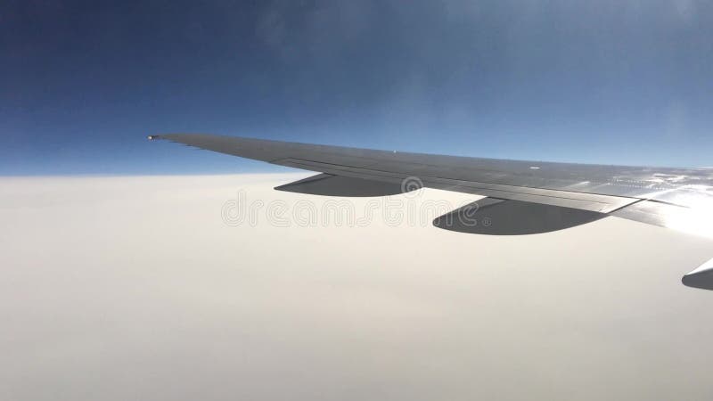 Взгляд от плоского окна на крыле и ландшафте под им Крыло летания самолета над облаками акции видеоматериалы