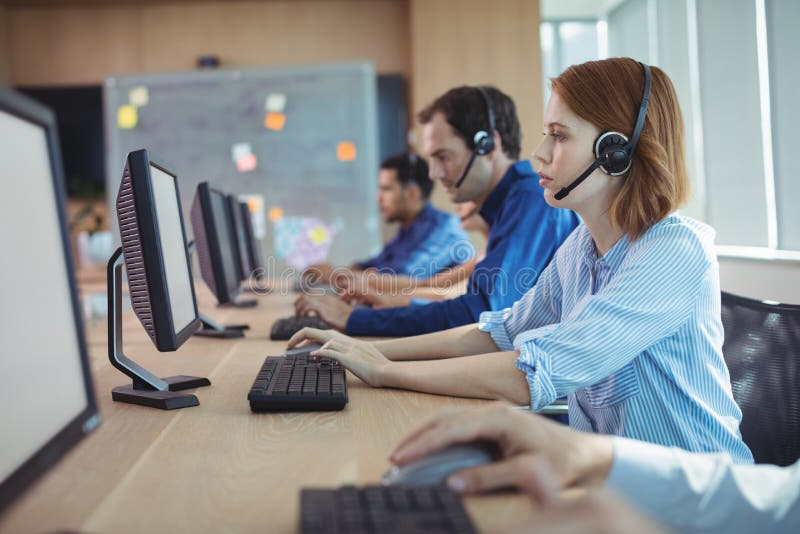 Взгляд со стороны коммерсантки работая в центре телефонного обслуживания стоковые изображения rf Взгляд со стороны коммерсантки работая в центре телефонного обслуживания стоковые изображения rf