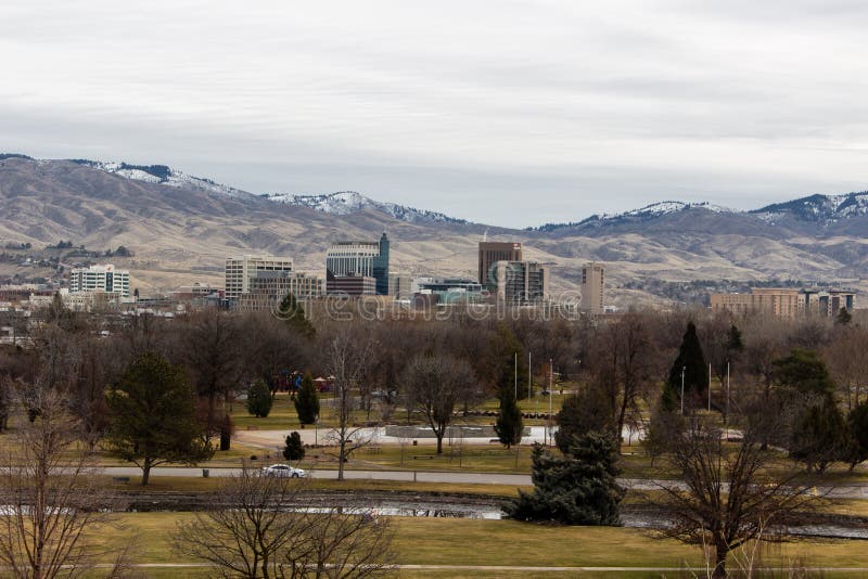 View of downtown Boise from across Kathryn Albertson Park. Winter day with a grey cloudy sky and snow capped mountains in the background. View of downtown Boise from across Kathryn Albertson Park. Winter day with a grey cloudy sky and snow capped mountains in the background.