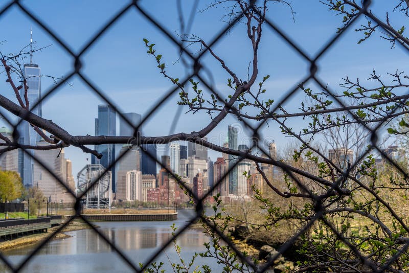 Взгляд городского пейзажа Нью-Йорка, более низкого Манхаттана от Jersey City через решетку стоковые изображения Взгляд городского пейзажа Нью-Йорка, более низкого Манхаттана от Jersey City через решетку стоковые изображения