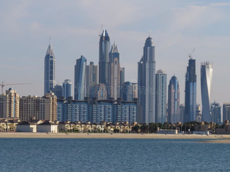 Взгляд искусственного острова ладони Jumeirah и небоскребов Дубай от пляжа аквапарк Aquaventure стоковые фотографии rf Взгляд искусственного острова ладони Jumeirah и небоскребов Дубай от пляжа аквапарк Aquaventure стоковые фотографии rf