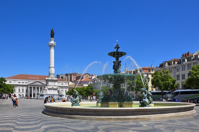 Взгляд квадрата Rossio при туристы идя, в центр города pombaline города Лиссабона, Португалия стоковое фото rf Взгляд квадрата Rossio при туристы идя, в центр города pombaline города Лиссабона, Португалия стоковое фото rf