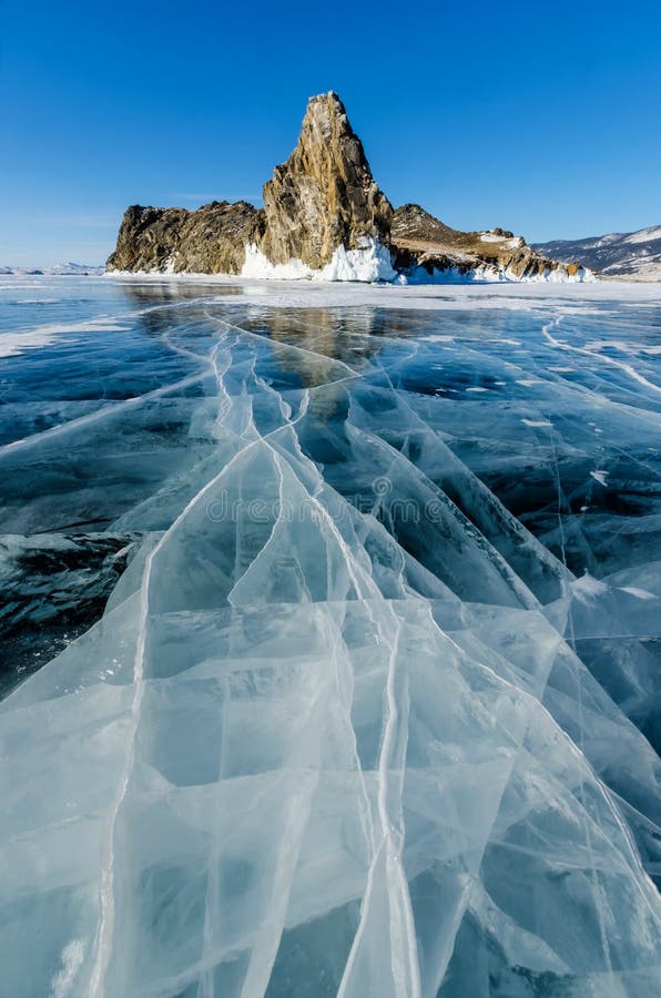 View of beautiful drawings on ice from cracks and bubbles of deep gas on surface of Baikal lake in winter with mountain, Russia. View of beautiful drawings on ice from cracks and bubbles of deep gas on surface of Baikal lake in winter with mountain, Russia